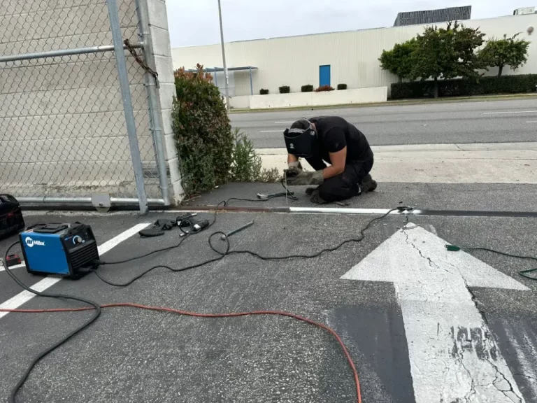 PLL technician welding on site during a gate repair
