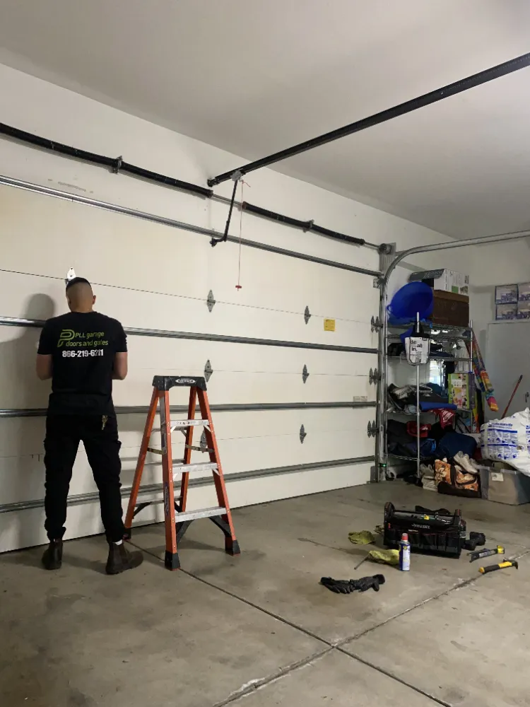 Uniformed PLL technician working on a residential garage door